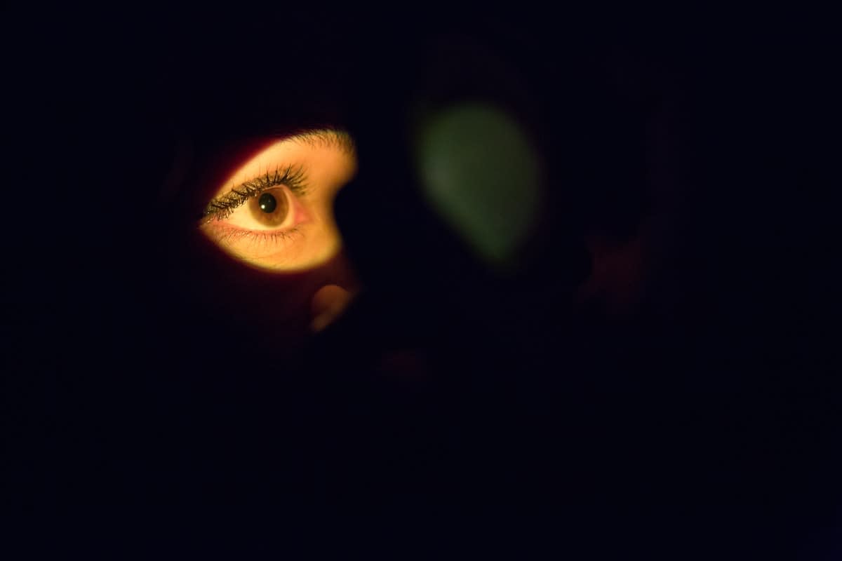 Close up of a person focusing on a screen in a dark room