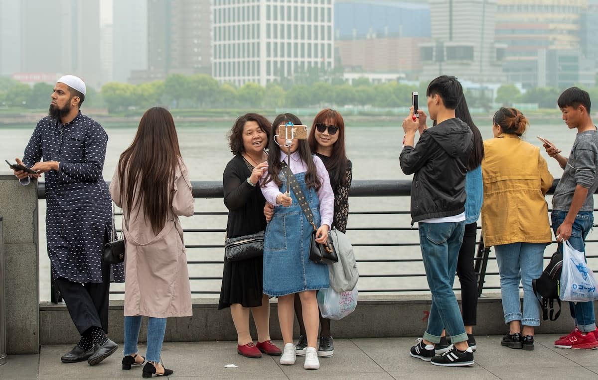 diverse group of people in a city looking at their phones