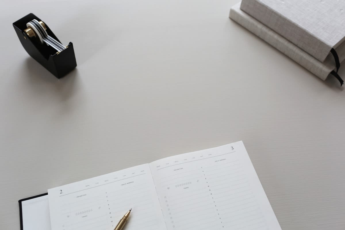 Person writing in a physical notebook in a clean office