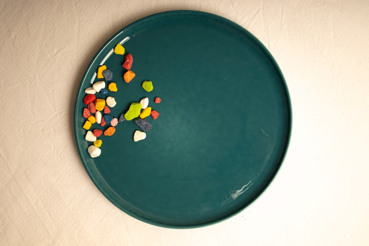 A top-down view of a plate divided into sections of greens, protein, and complex carbohydrates