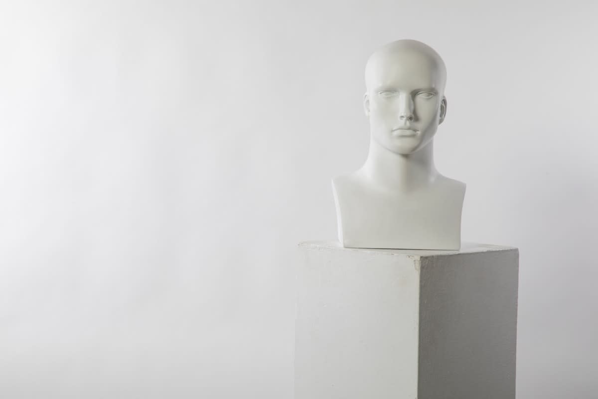 Minimalist sculpture of a human head with a gear mechanism inside