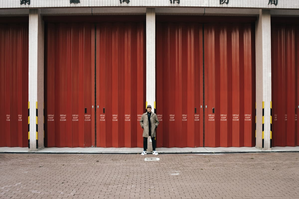 A person standing before a massive wall of identical doors
