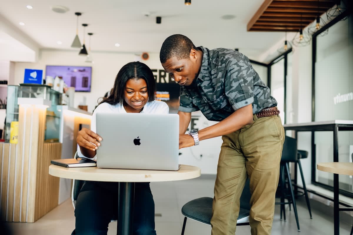 Two people working on laptops in a modern cafe