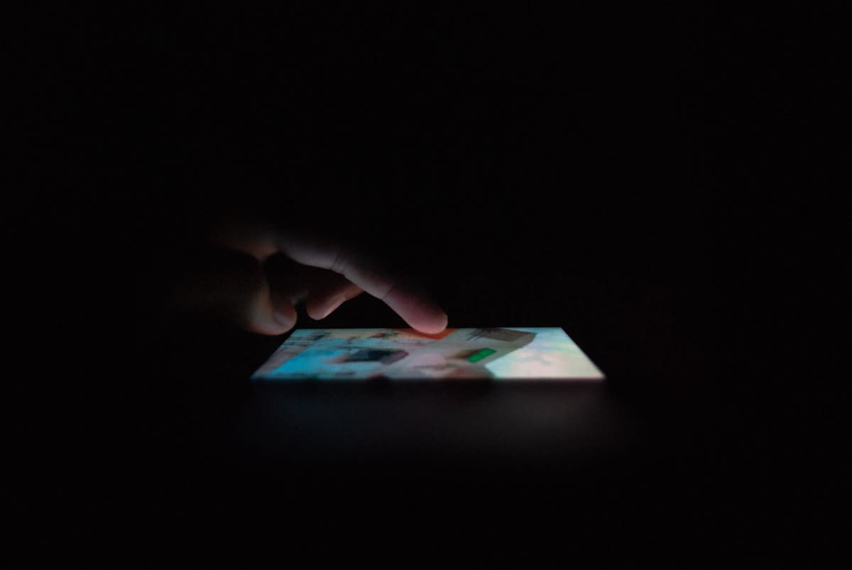 person looking at a smartphone screen in a dark room