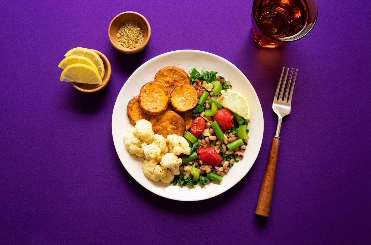 A plate divided into sections showing vegetables, protein, and a small portion of grains