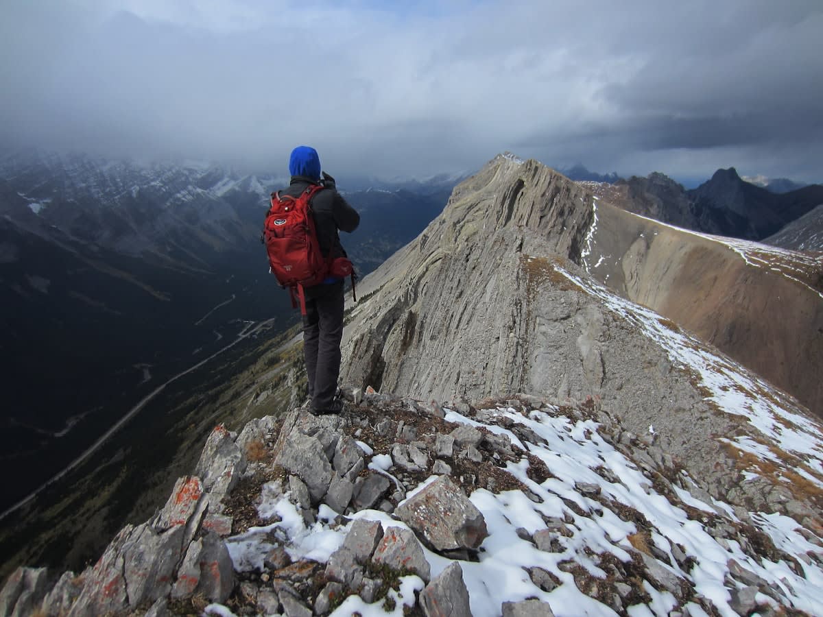 A high-altitude mountain climber pausing at a ridge