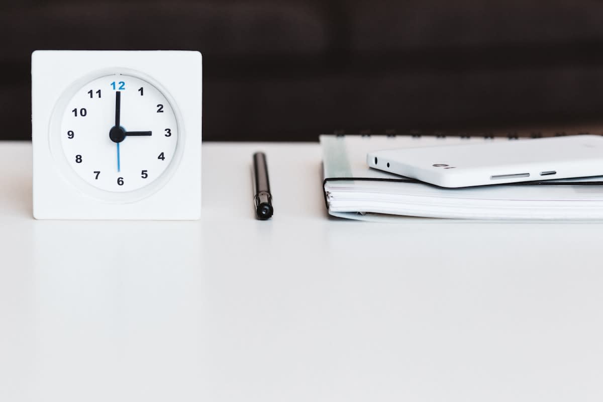 A minimalist desk with a precision timer and a notebook