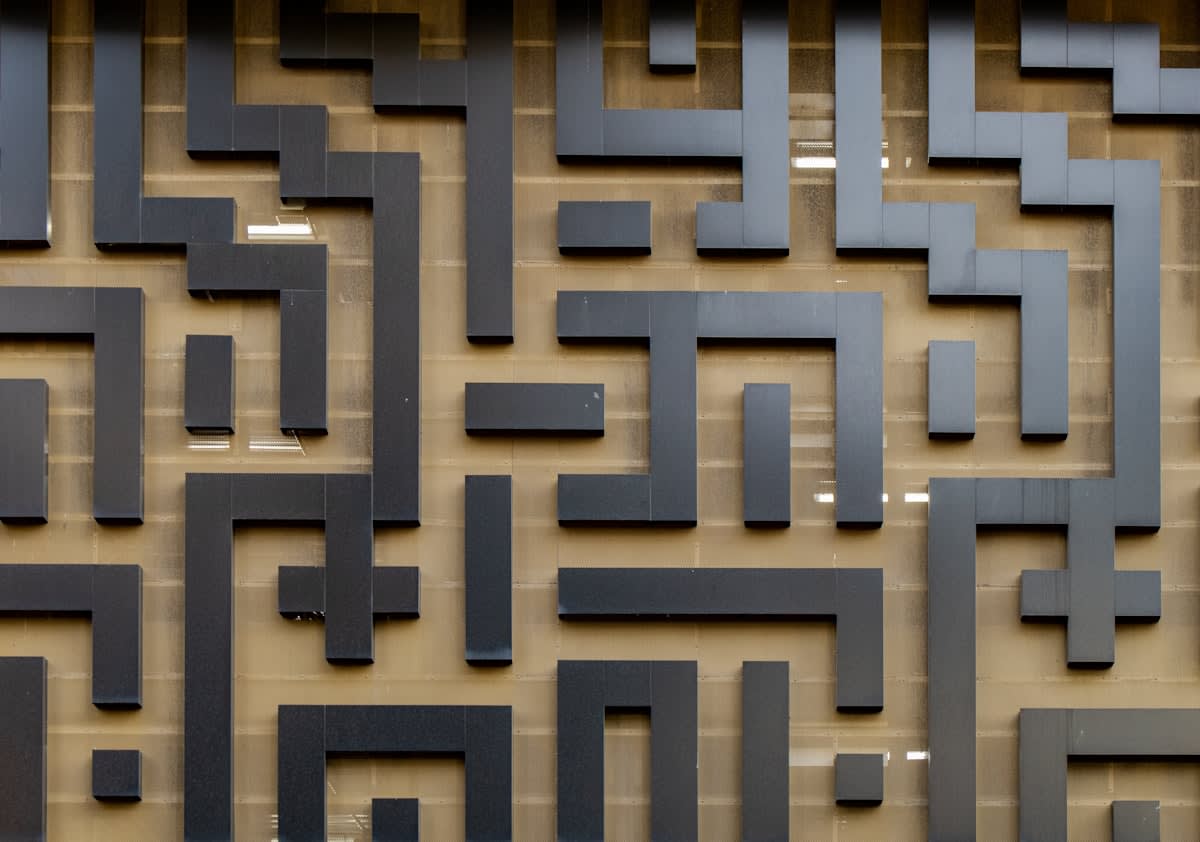 An abstract representation of a maze with a path breaking through the wall