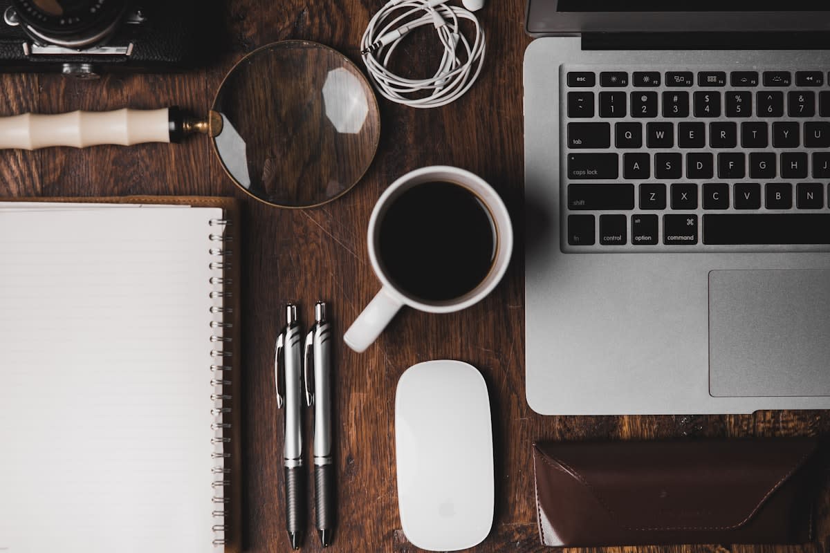 A clean, minimalist workspace with a single notebook and a cup of coffee