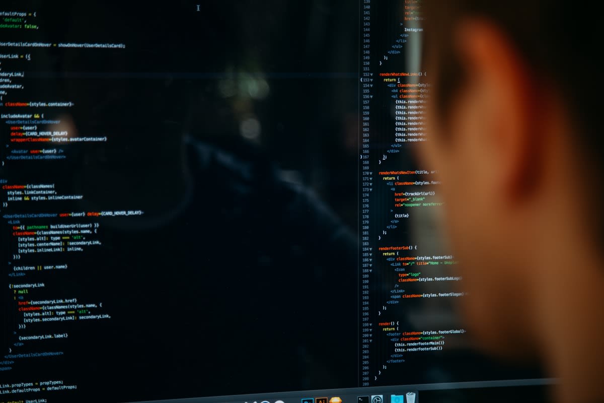 Close up of a professional in a suit looking at a screen with code