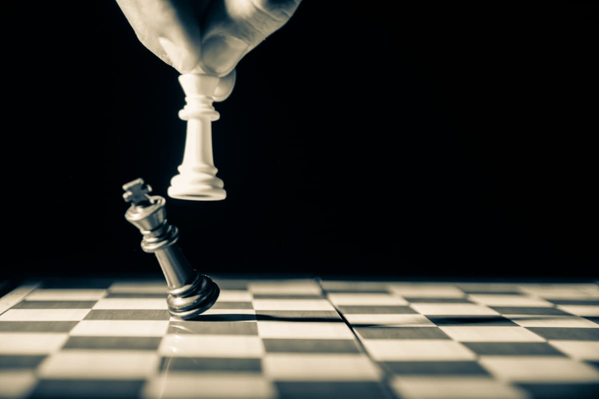 Close up of a chess piece being moved on a board