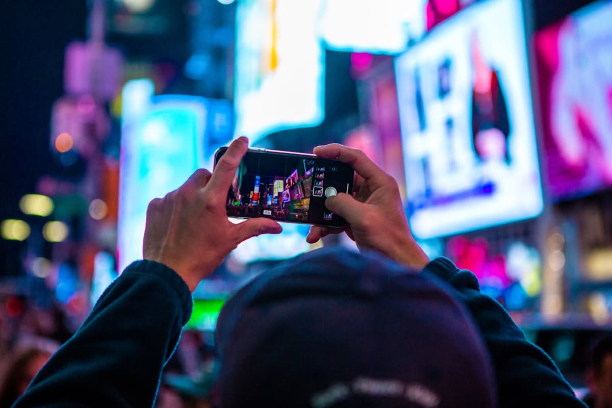 Person using a smartphone in a crowded neon city