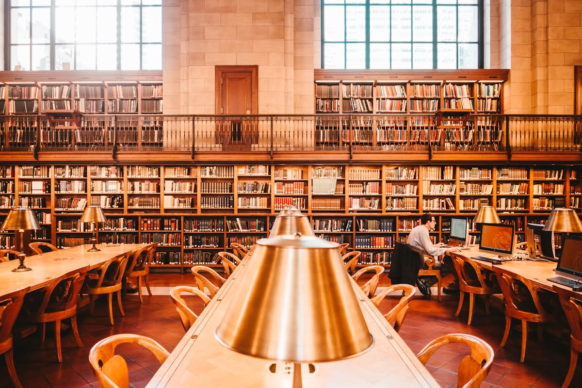 A wide shot of a modern library or a study with various books and tools