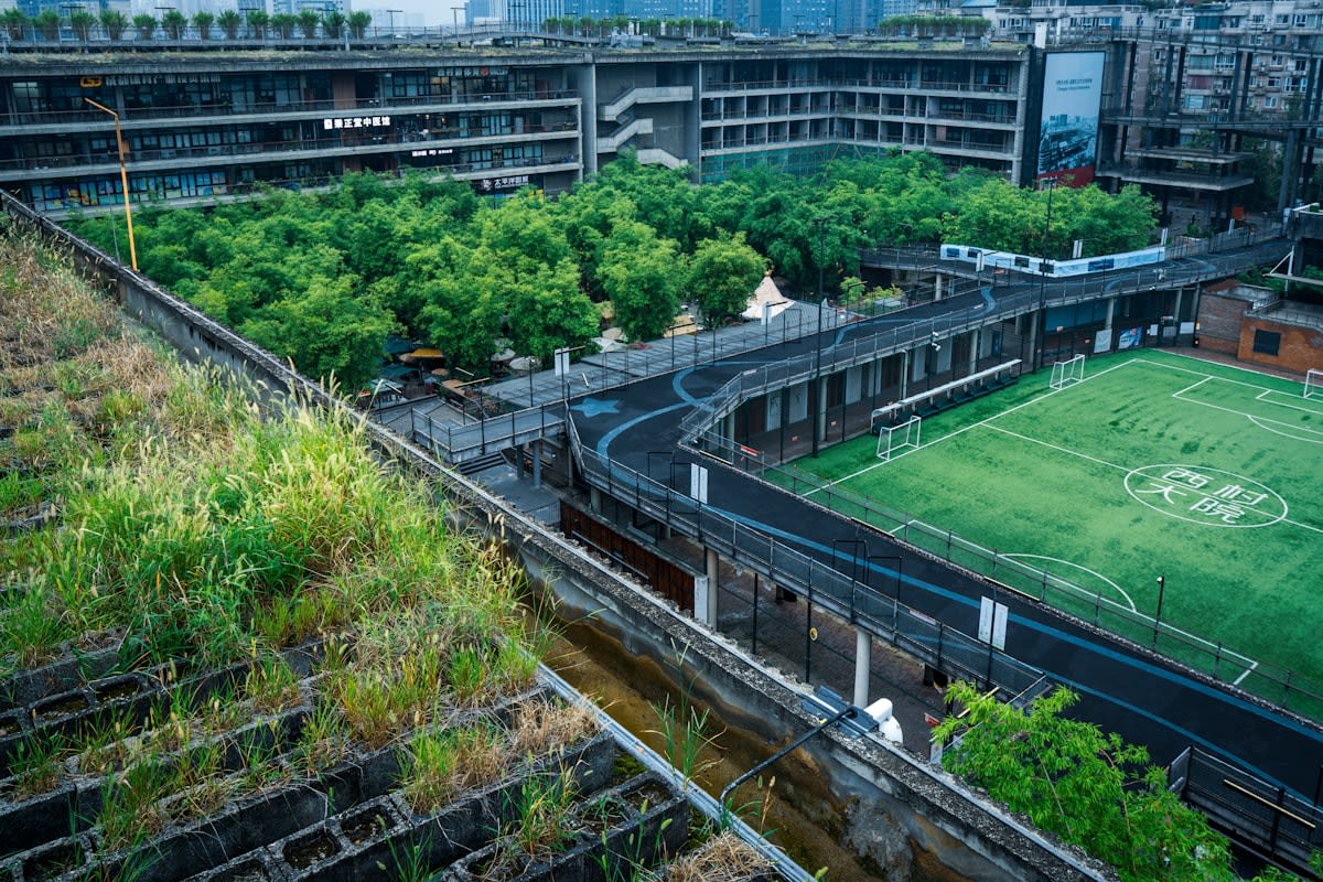 Aerial view of a green corridor cutting through a dense cityscape