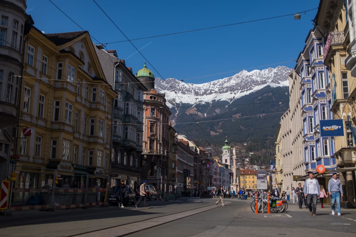 A split screen showing a crowded city street and a quiet home office with a view of mountains