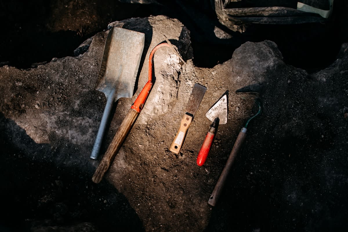 Archaeological dig site with brushes and tools