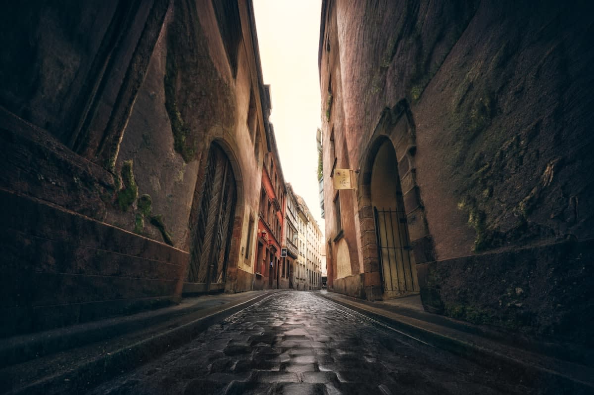 A quiet, narrow street in an ancient European city during early morning