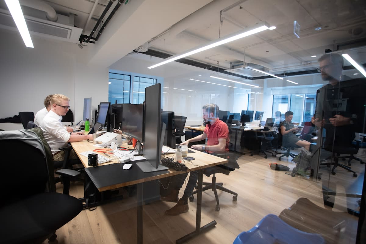 People working in a modern, light-filled co-working space