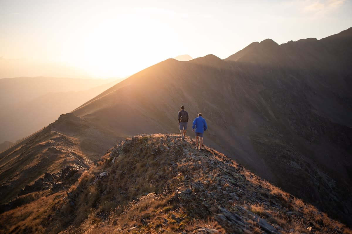 Ultra runner traversing a rugged mountain ridge at dawn