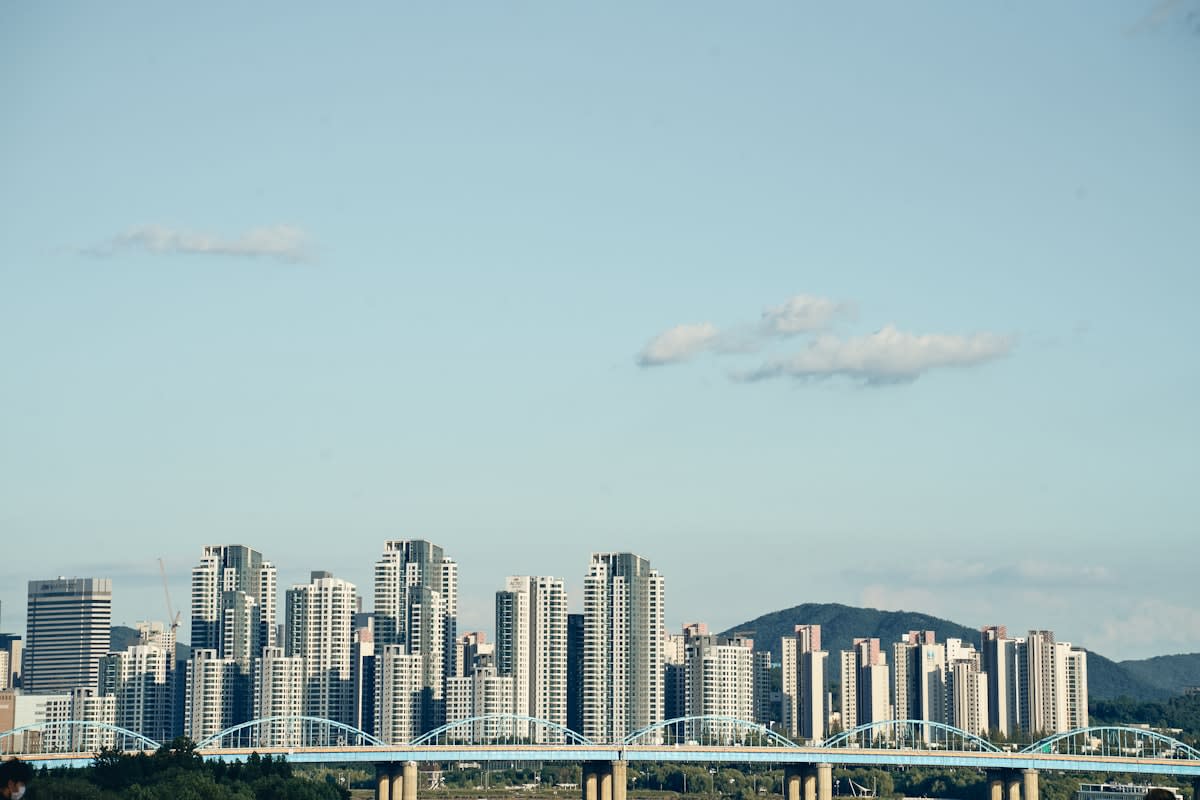 A wide shot of a modern city skyline with a bridge connecting two distinct architectural styles
