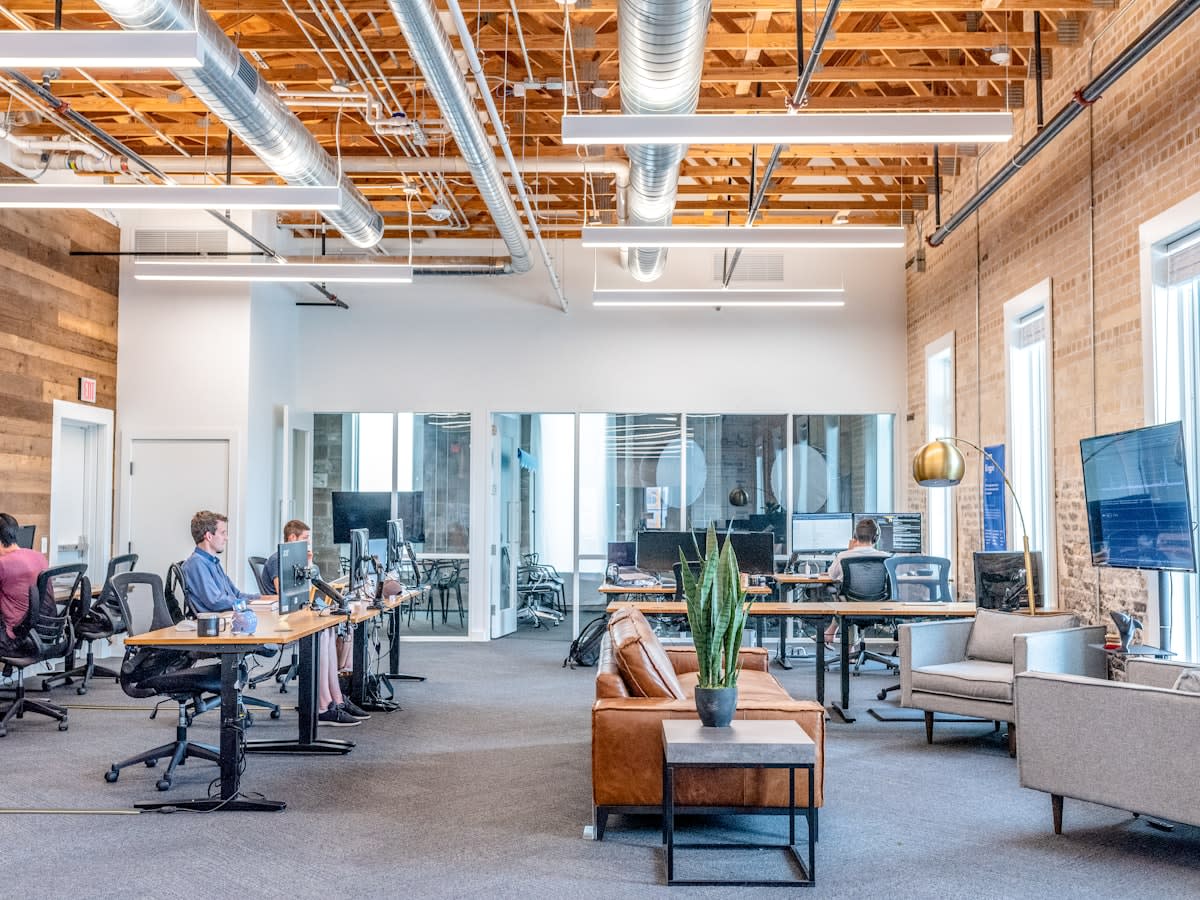 Modern collaborative workspace with diverse young professionals using multiple screens