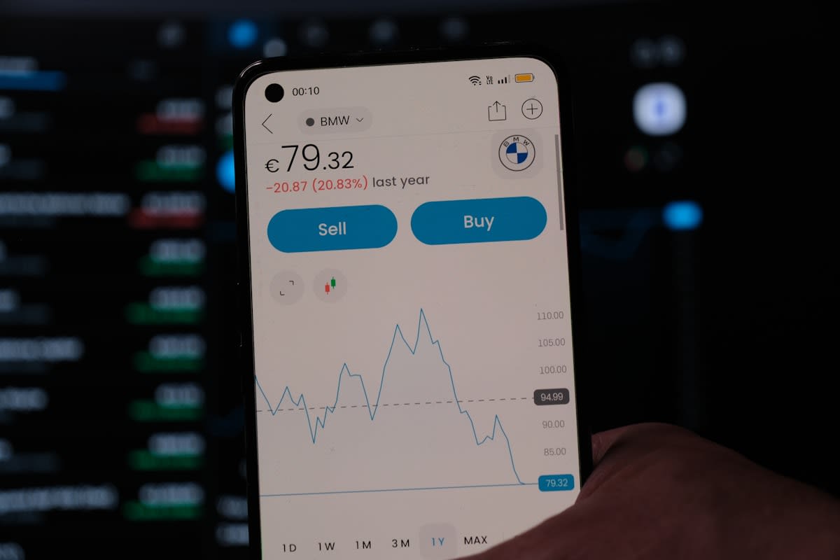 Close up of a smartphone screen with a financial app in a busy market
