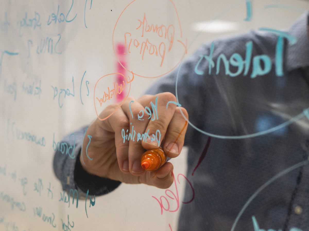 Person analyzing a complex flowchart of cognitive tasks on a whiteboard