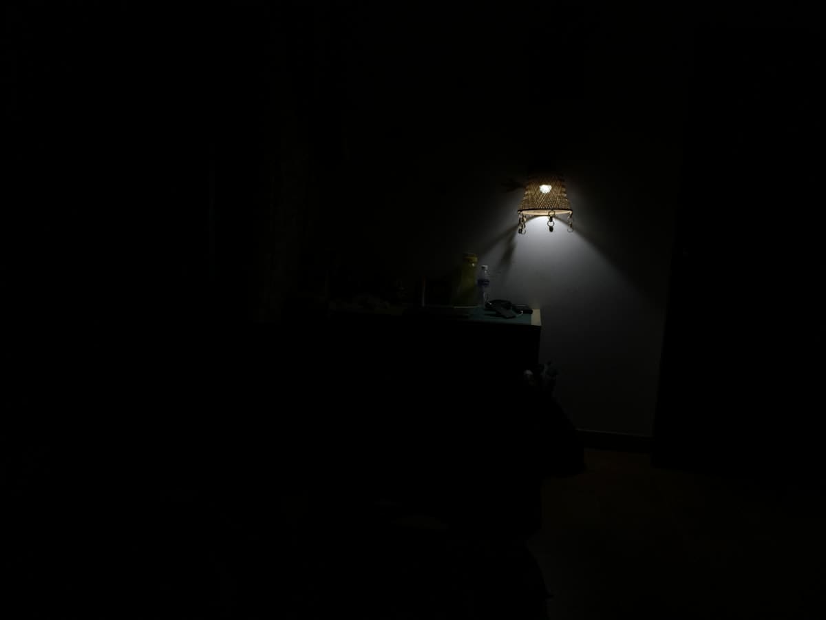 A person focusing on a single point of light in a dark room