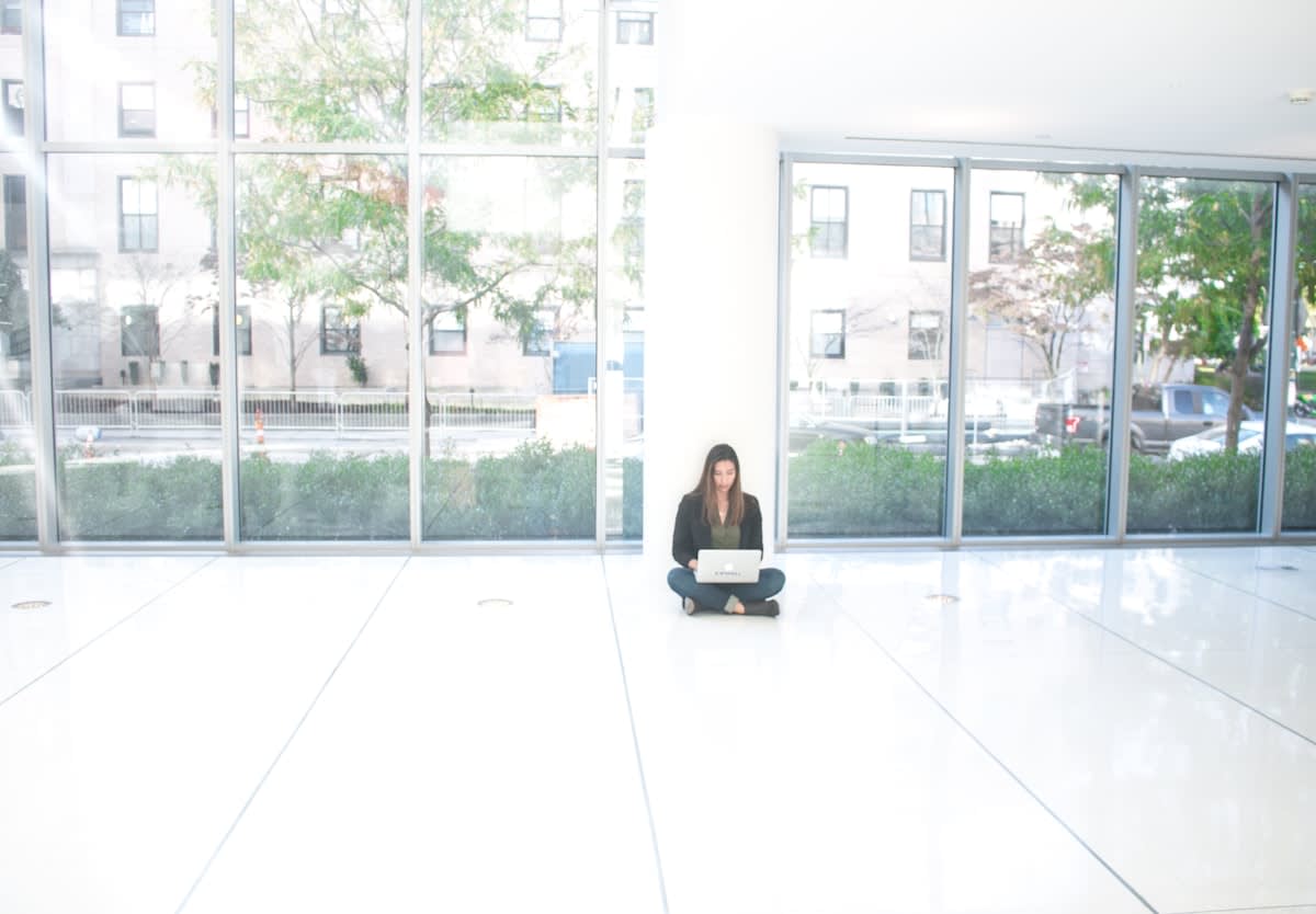A person meditating in a stark, empty white room