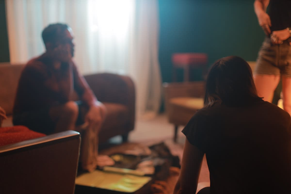 A small group of people in a deep conversation in a dimly lit room