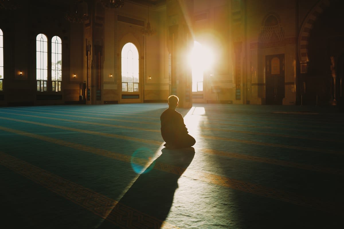 Person meditating in morning sunlight