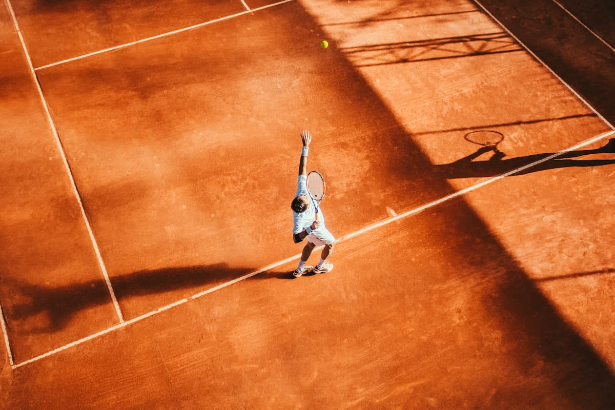A professional tennis player pausing before a serve