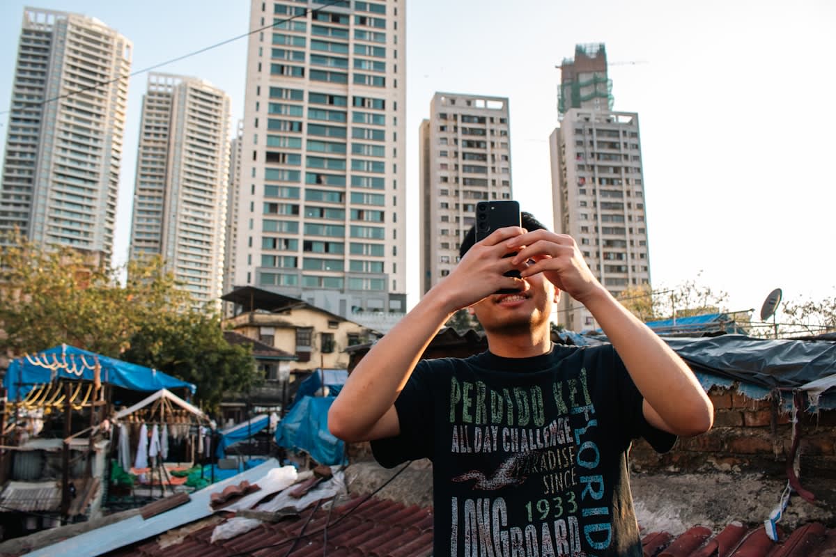 person holding a vintage flip phone in a modern city