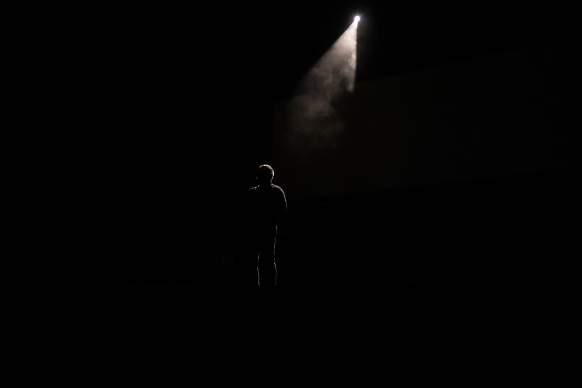Person standing on a stage looking focused and energetic