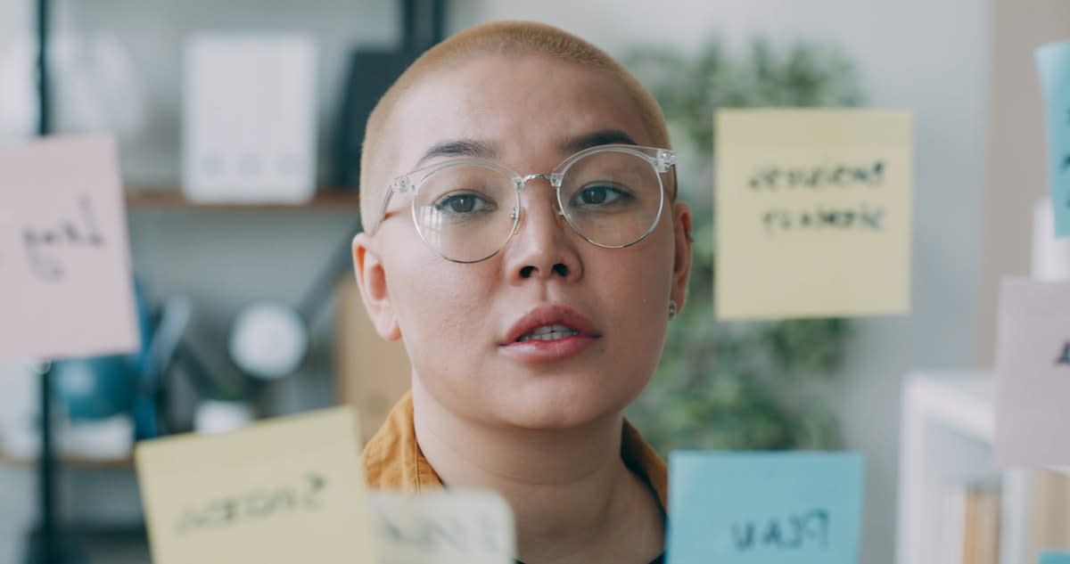 A person auditing a list of goals with a focused expression