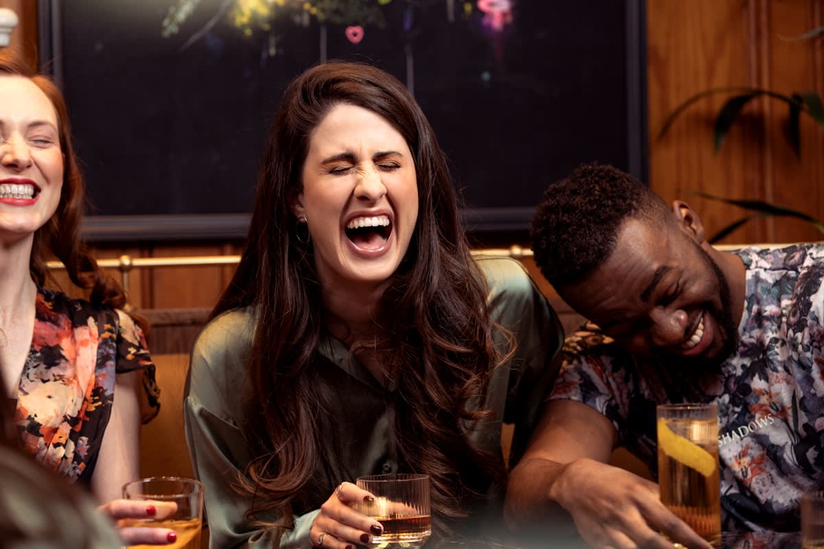 Group of diverse adults laughing together in a cozy indoor setting