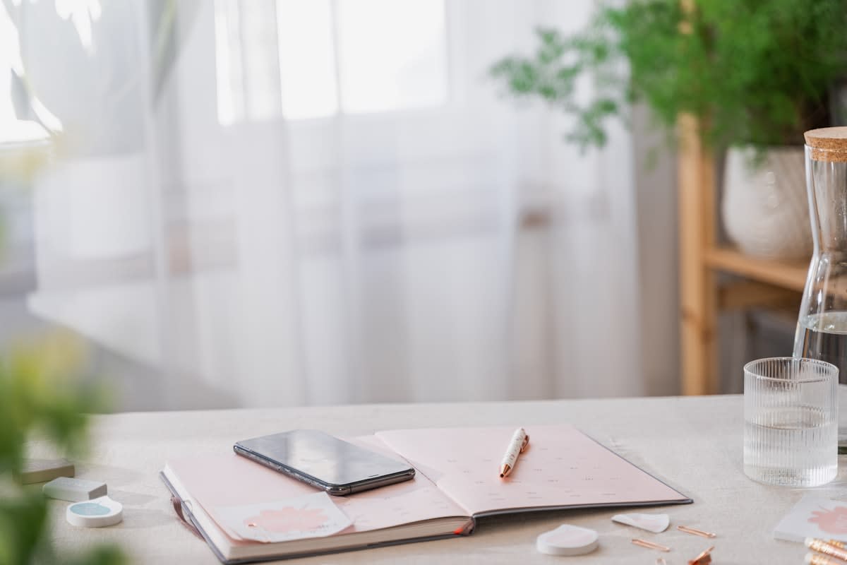 A clean, organized workspace with a notebook and a glass of water