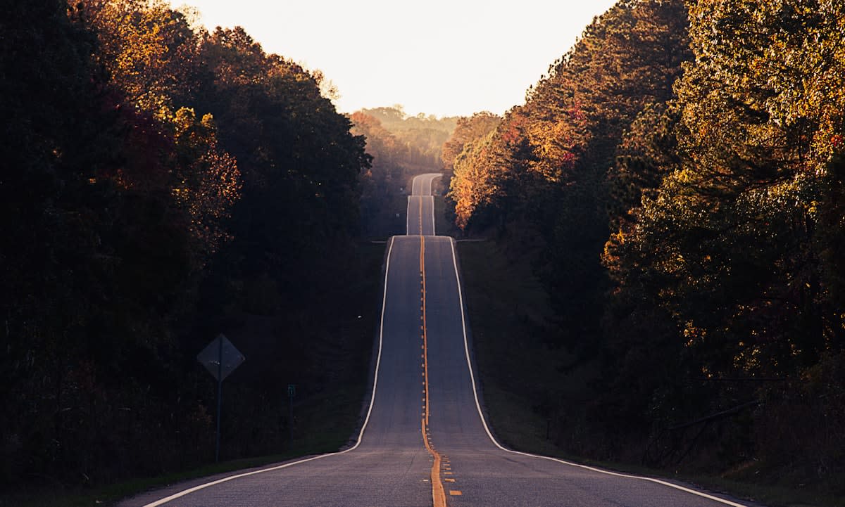 A clean, open road leading toward a sunrise