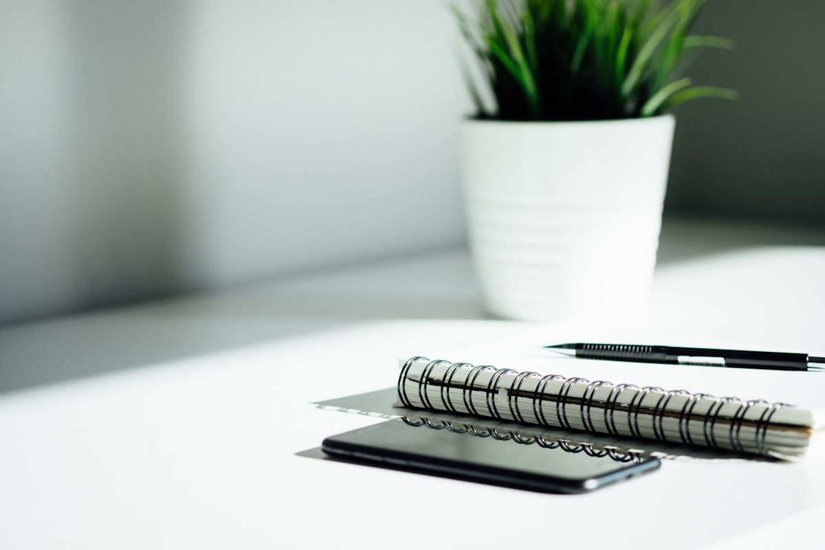 Minimalist workspace with a physical notebook and a turned-off smartphone