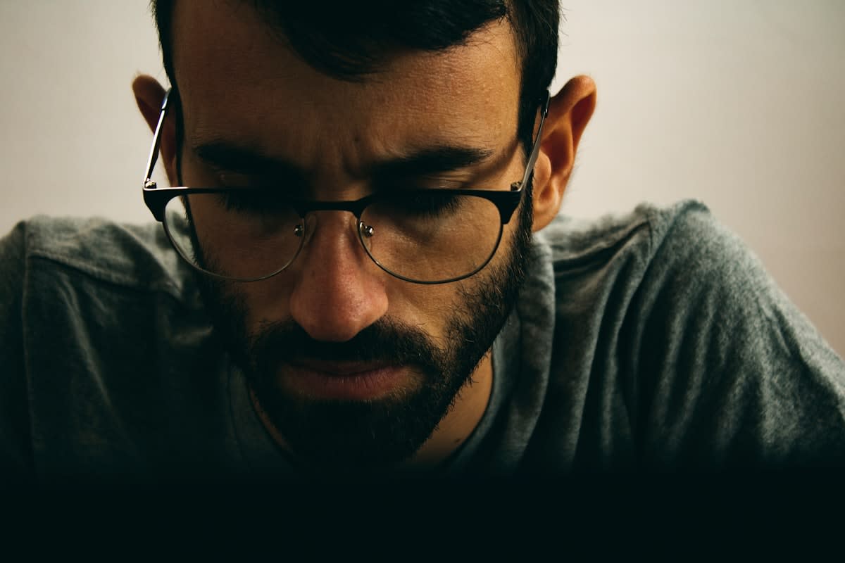 Close up of a person looking stressed while staring at a loading screen