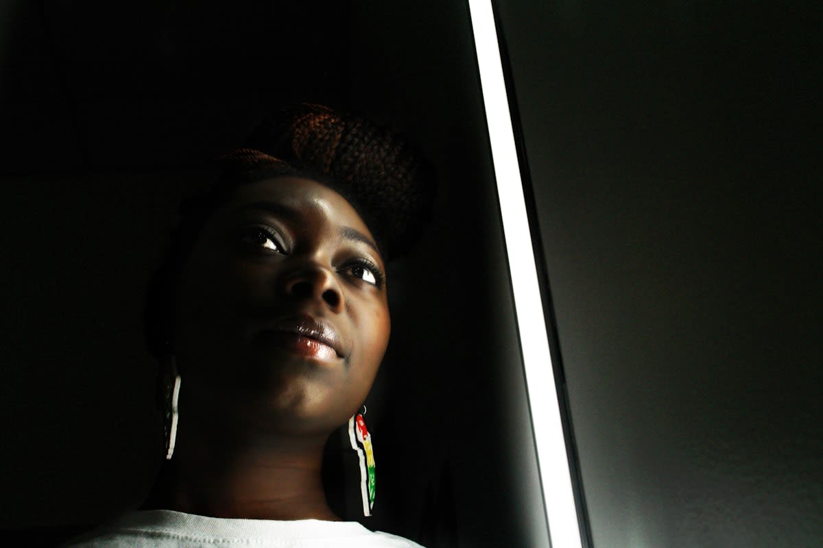 Dark room with a single glowing screen reflecting on a face