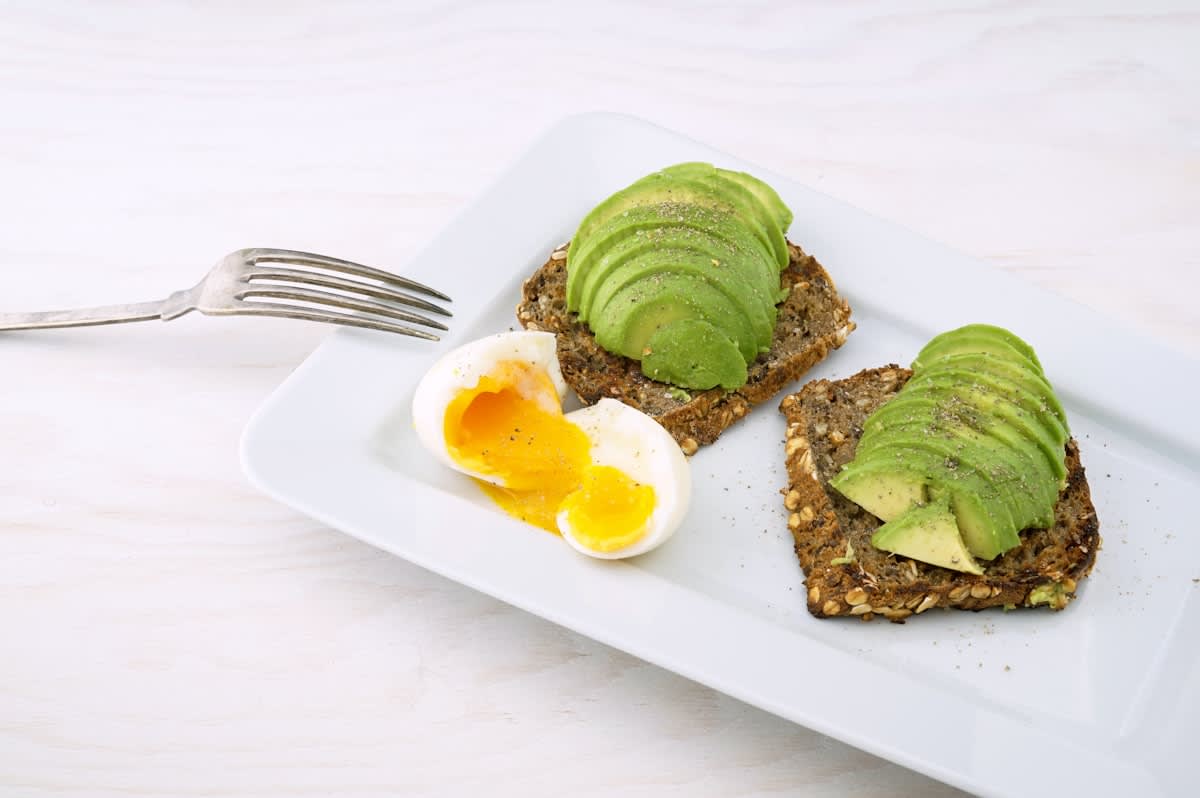 Close up of high protein foods like eggs, avocado, and lean meats