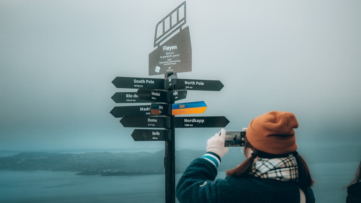 A person standing at a crossroads with hundreds of signs pointing in different directions