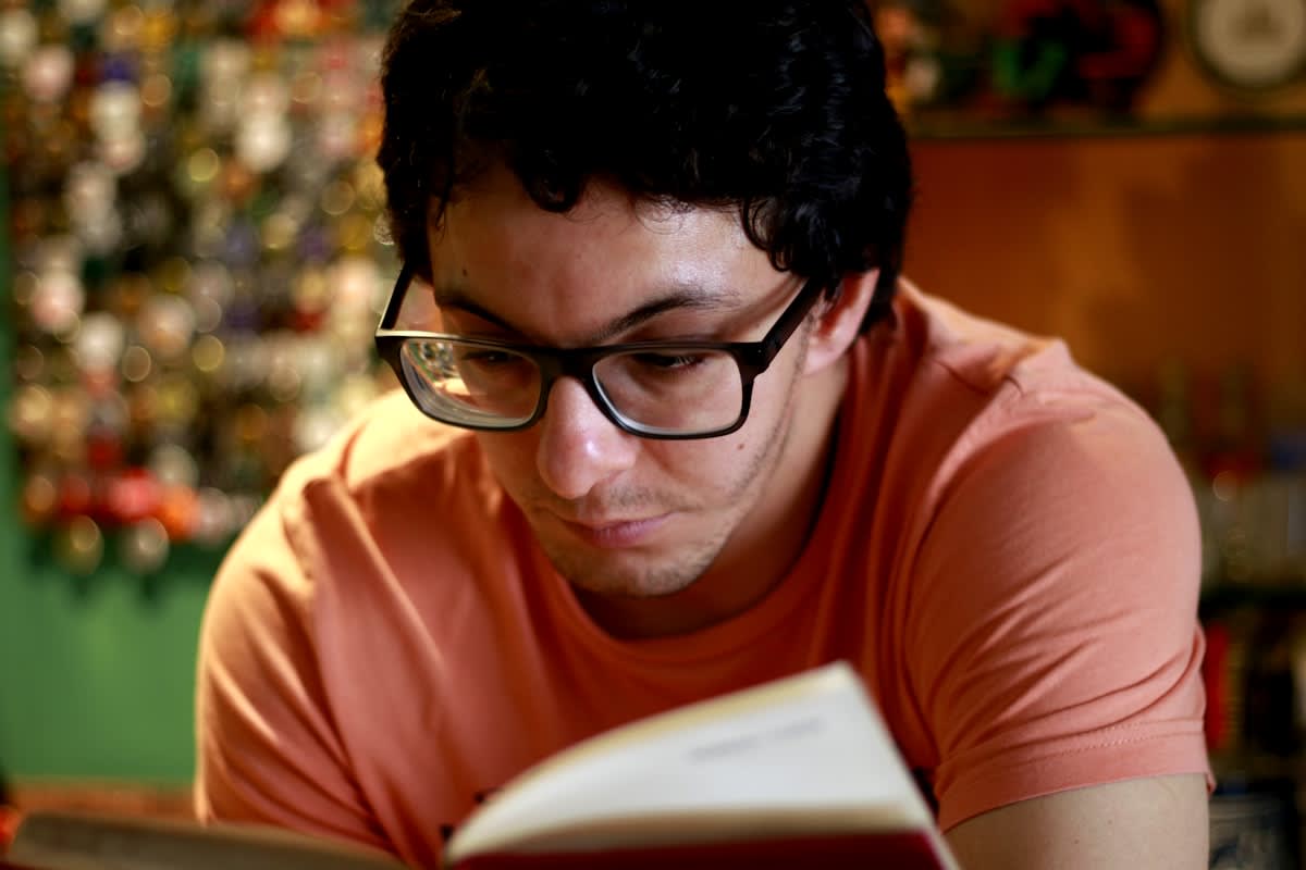Person studying a complex book with a focused expression