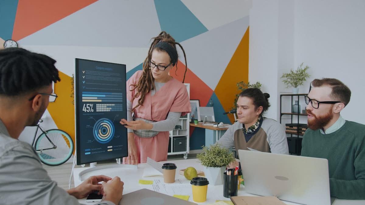 A diverse team of professionals collaborating around a table with digital screens