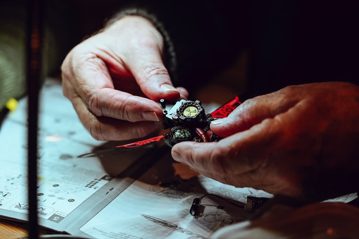 Close up of hands working on a complex mechanical watch