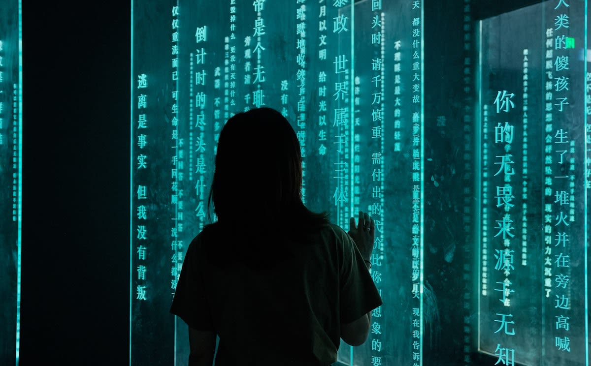person looking at a wall of screens with data