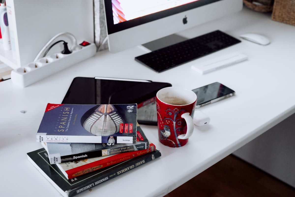 A minimalist workspace with a mix of analog books and a digital tablet