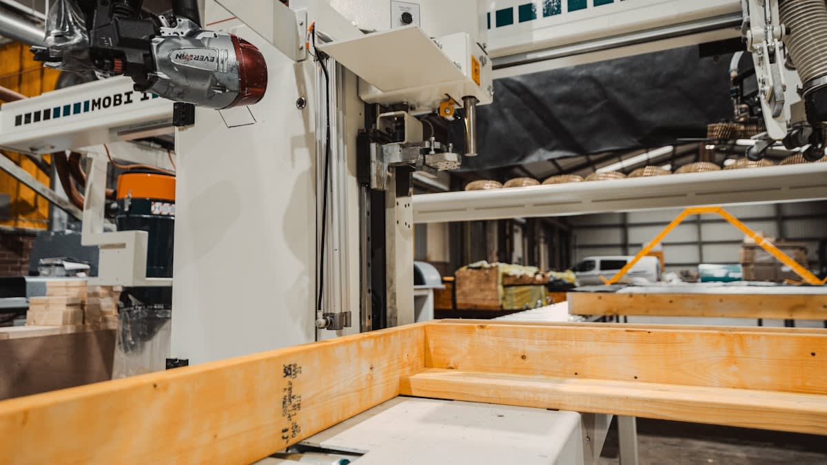 Close up of robotic arm and human hand in a factory setting