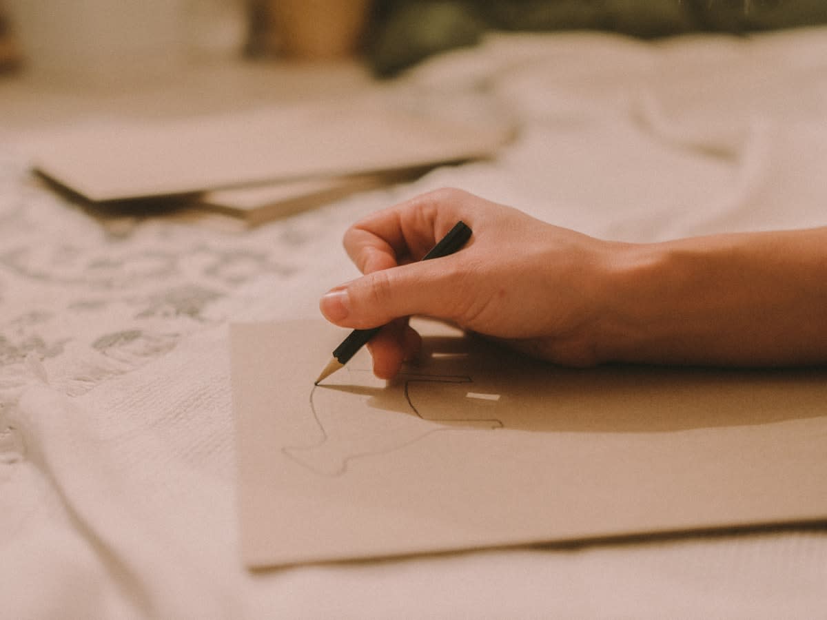 Close up of a human hand sketching in a notebook